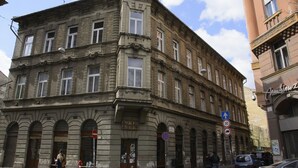 Un edificio histórico con varias ventanas y una entrada en esquina.