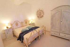 Una camera da letto con un letto, comodini, un armadio e un elemento decorativo a parete.