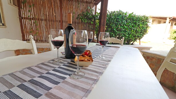 A table set with wine glasses, a bottle, and a bowl of bread. - Casa Primus Torre Santo Stefano in Otranto (Otranto)