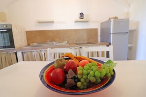 A kitchen with a bowl of fruit on the table.