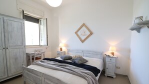Una camera da letto con un letto, comodini, una scrivania, un armadio e una finestra.