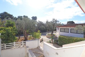 Un quartier résidentiel avec un immeuble blanc, un escalier et de la verdure environnante.