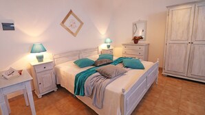 A bedroom with a bed, nightstands, a dresser, and a wardrobe.