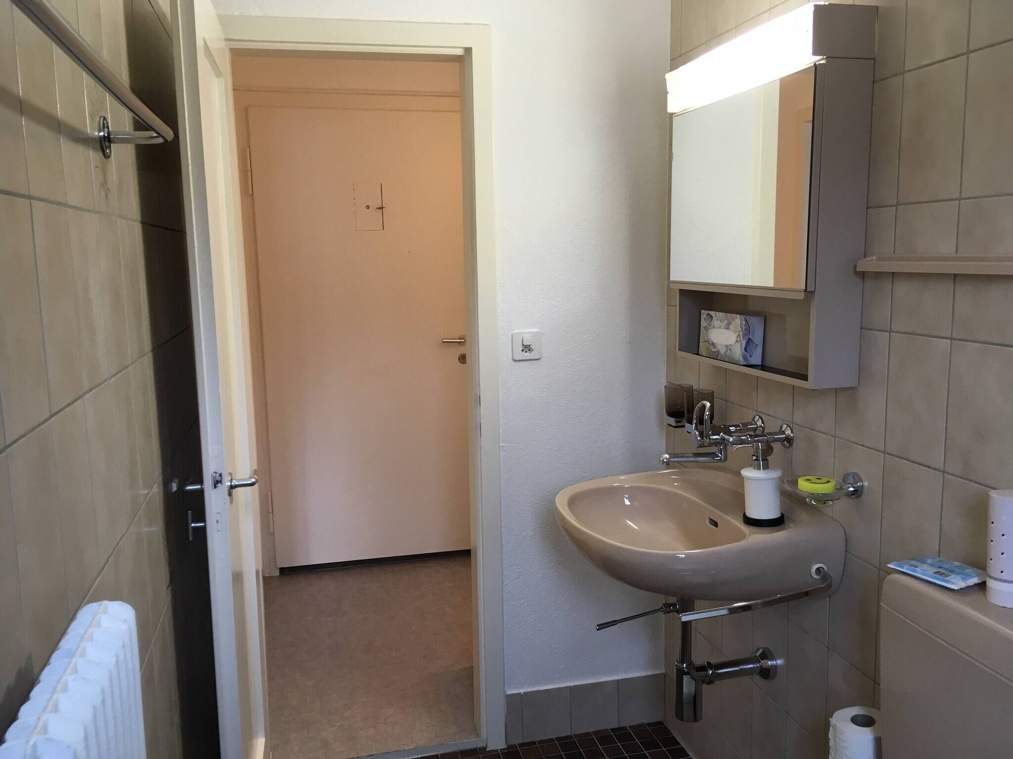 A bathroom with a sink, mirror, and toilet.