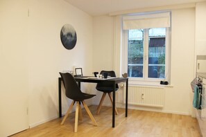 Un coin repas avec une table et des chaises, une fenêtre donnant sur un paysage agréable et un radiateur.