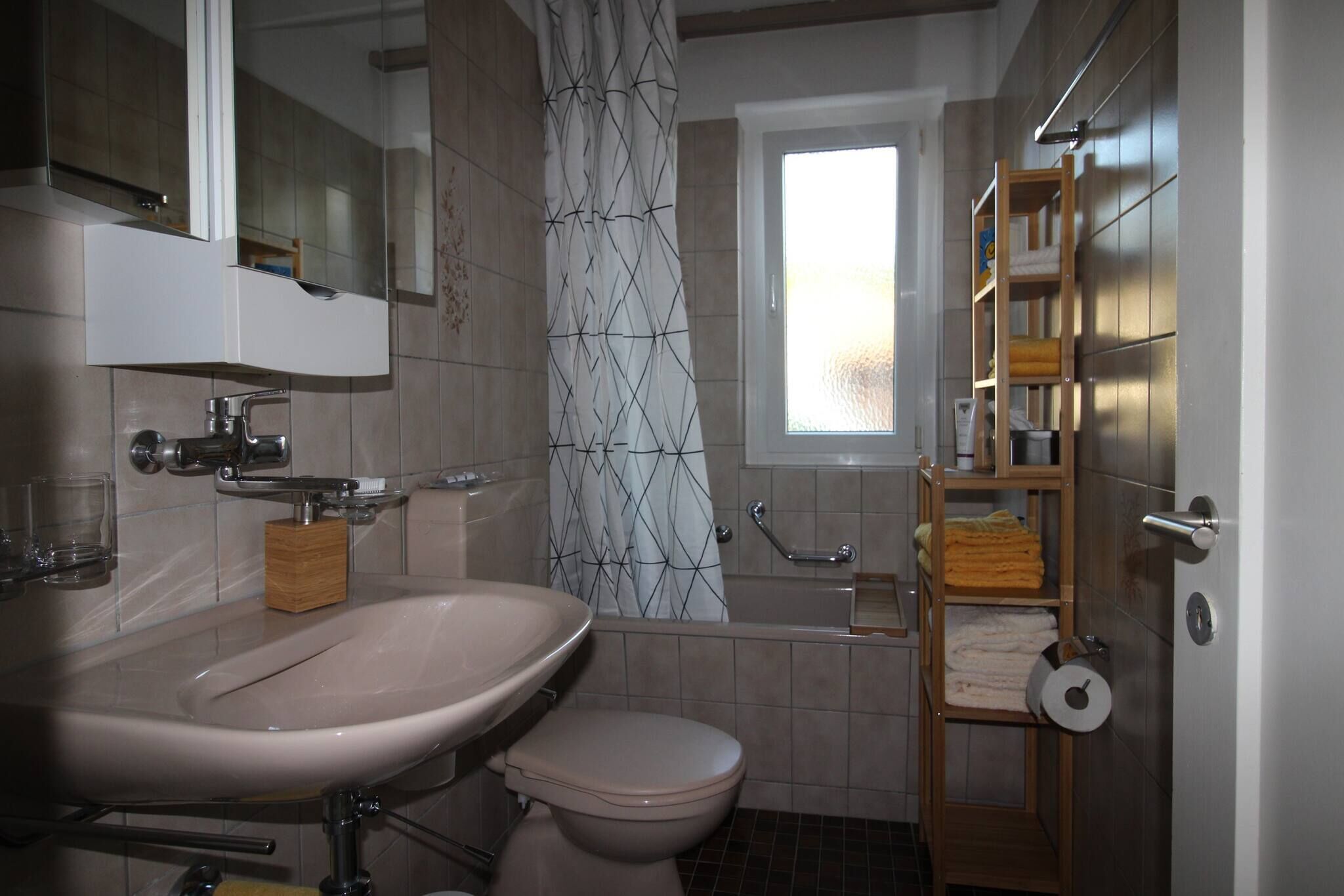 Ein Badezimmer mit Waschbecken, Toilette, Dusche und einem Fenster.