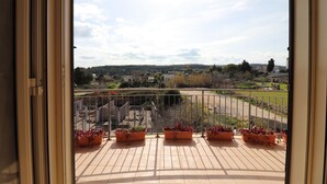 A balcony with potted plants, a view of a park, and a distant landscape. - Elegant Holiday Home for 6–7 Guests in the Heart of Otranto (Otranto)