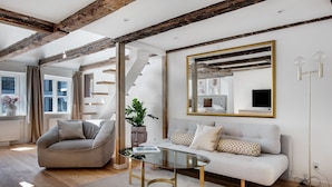 A modern living room with a glass coffee table, a sofa, and a large mirror. - Regent 6- Cozy 1-Bdr Apt with Terrace in the Centre of Copenhagen (København)