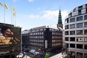 A multi-story building with a modern architectural design, featuring a prominent GANNI sign on the facade. - Regent 6- Cozy 1-Bdr Apt with Terrace in the Centre of Copenhagen (København)