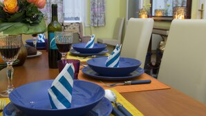 A dining table set with blue plates, a bottle of wine, and a bouquet of orange flowers. - Stunning 2 Double Bedroom Apartment In The Centre Of Budapest (Budapest)