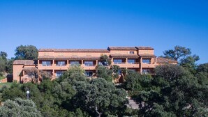 A multi-story building with a terracotta roof, surrounded by dense greenery. - Air-conditioned apartment near Porto Vecchio, 500 m sea, 6 people, two bathrooms (Zonza)