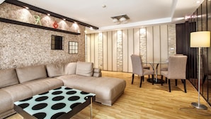 A modern living room with a sectional sofa, a patterned coffee table, and a dining area with chairs and a table.