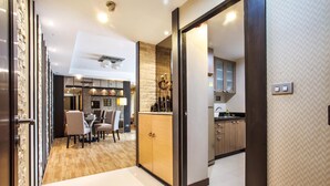 A modern kitchen with wooden cabinets, a dining area with chairs, and a visible kitchen counter.