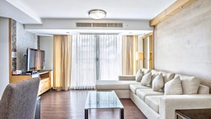 A modern living room with a sofa, a glass coffee table, a TV, and a fireplace. - 3A - Short-Term Rental Allowed - Downtown Bkk Serviced Apartment (Krung Thep Maha Nakhon)