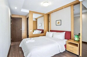 Una habitación de hotel con una cama grande, una mesita de noche de madera, un espejo y un cuadro en la pared.