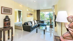 A living room with a sofa, coffee table, lamp, statue, and artwork. - 6-35 - 3 Bdr Condo with Balcony and shared Pool (Tambon Patong)