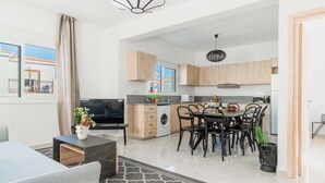 Apartamento moderno com sala de estar, área de jantar, cozinha e varanda.