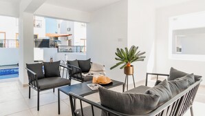Uma sala de estar moderna com um conjunto de sofá, uma mesa de centro e uma planta em vaso.