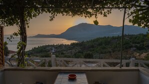 A terrace with a table and chairs, overlooking a body of water and mountains. - Apartment with Pool and Panorama View (Koumeika)