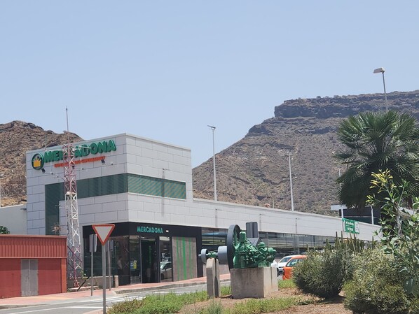A Mercadona store with a modern design, located near a mountainous area.