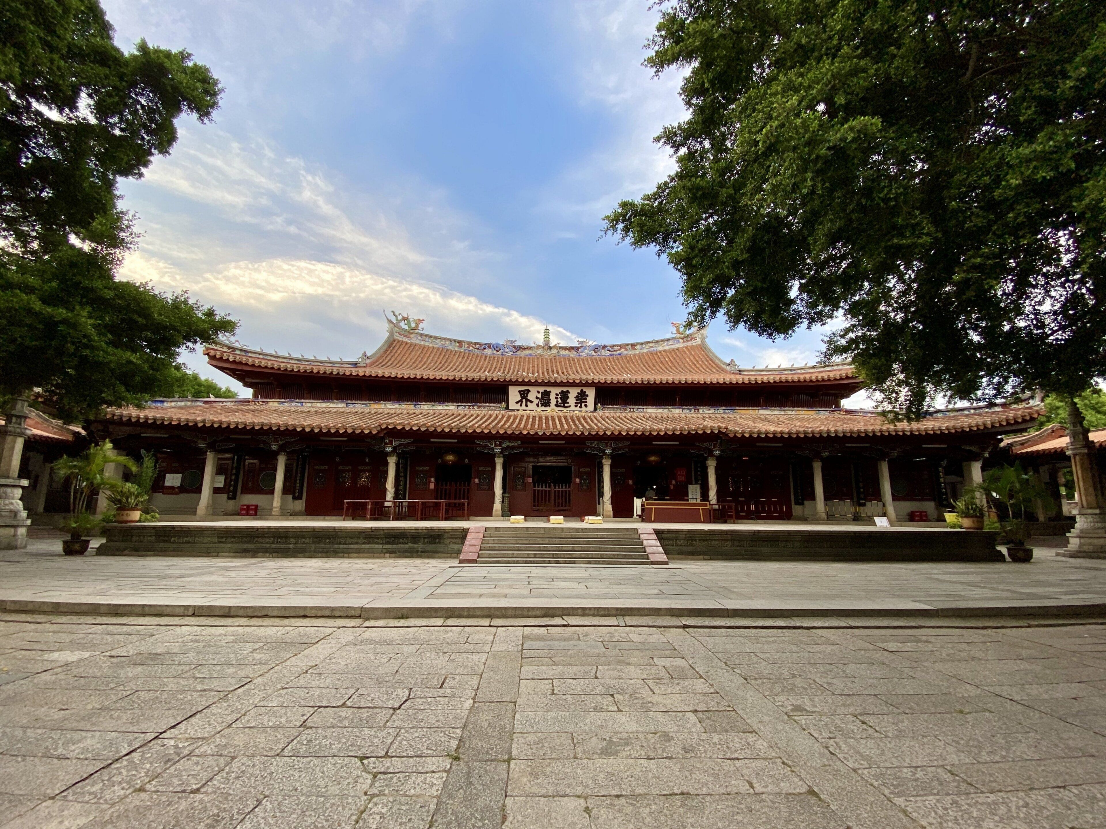 A traditional Chinese building with a tiled roof and a signboard.