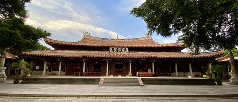 A traditional Chinese building with a tiled roof and a signboard.