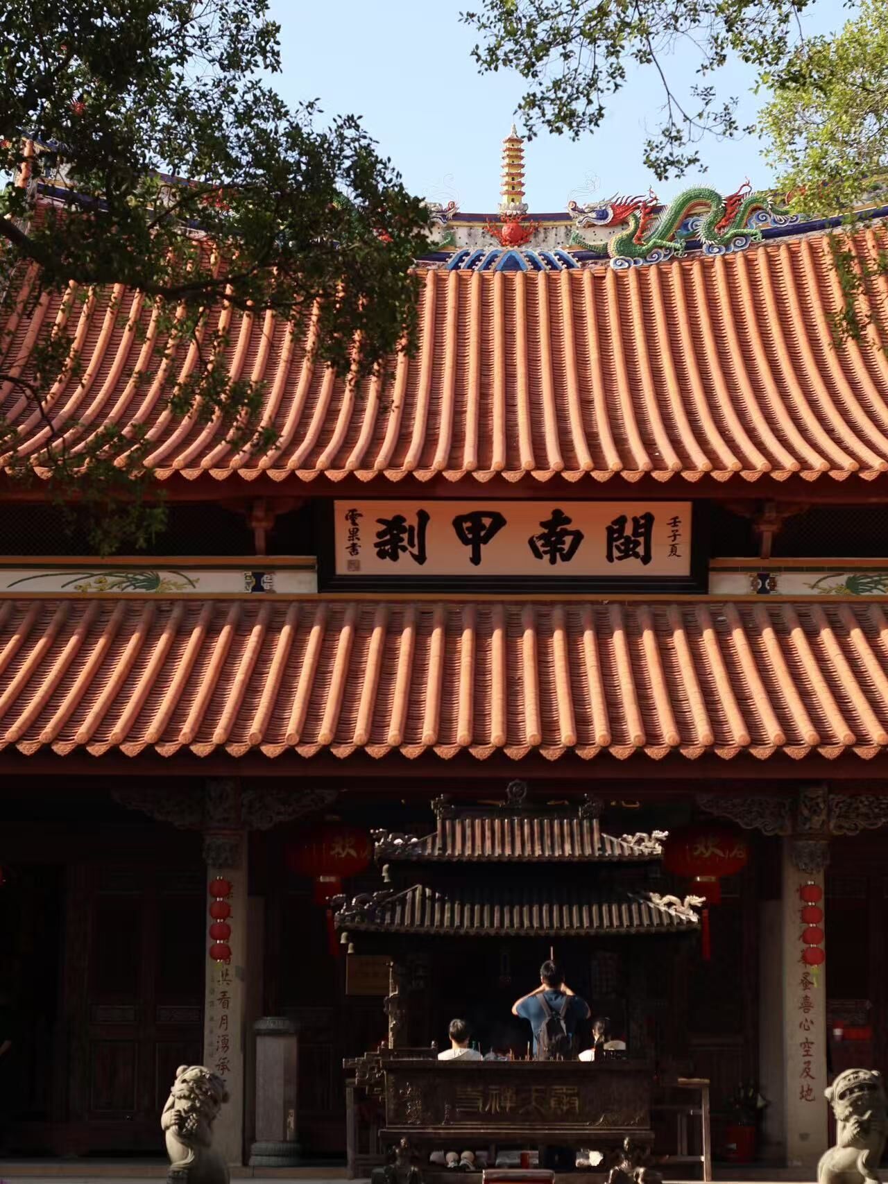 Un bâtiment traditionnel chinois, doté d’un toit recouvert de tuiles et d’une enseigne.