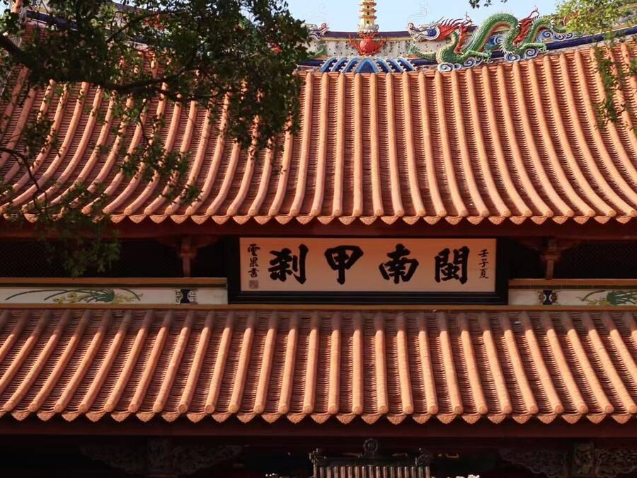 Un bâtiment traditionnel chinois, doté d’un toit recouvert de tuiles et d’une enseigne.