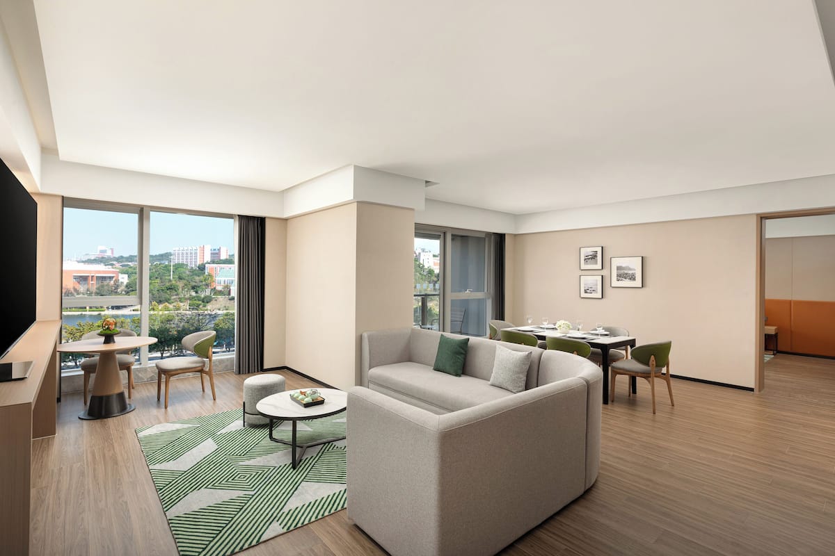 Una sala moderna con sofá, mesa de comedor, sillas y televisor.