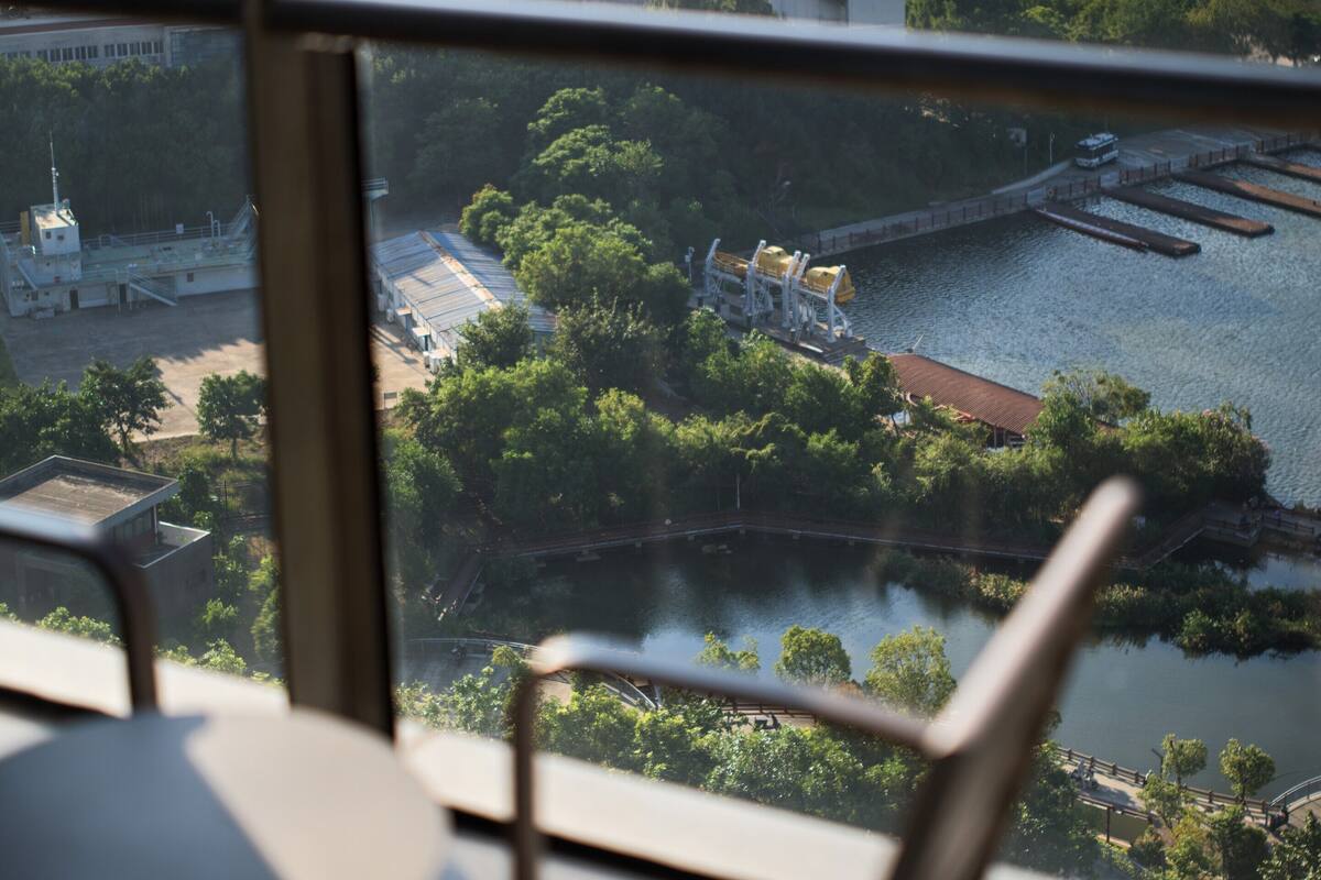 Vista desde un balcón sobre un río, con edificios y vegetación.