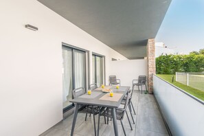 Un balcón con una mesa lista para dos personas, mostrando un desayuno preparado.
