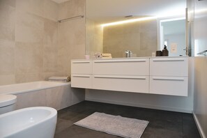 Kombination af bruser/badekar, hårtørrer, håndklæder