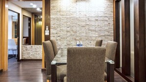 A conference room with a brick wall, a glass table, and four chairs. - 3C - Short-Term Rental Allowed - Downtown Bkk Serviced Apartment (Krung Thep Maha Nakhon)