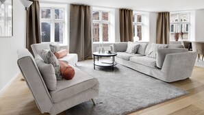 En moderne stue med sofa, lænestol og sofabord.