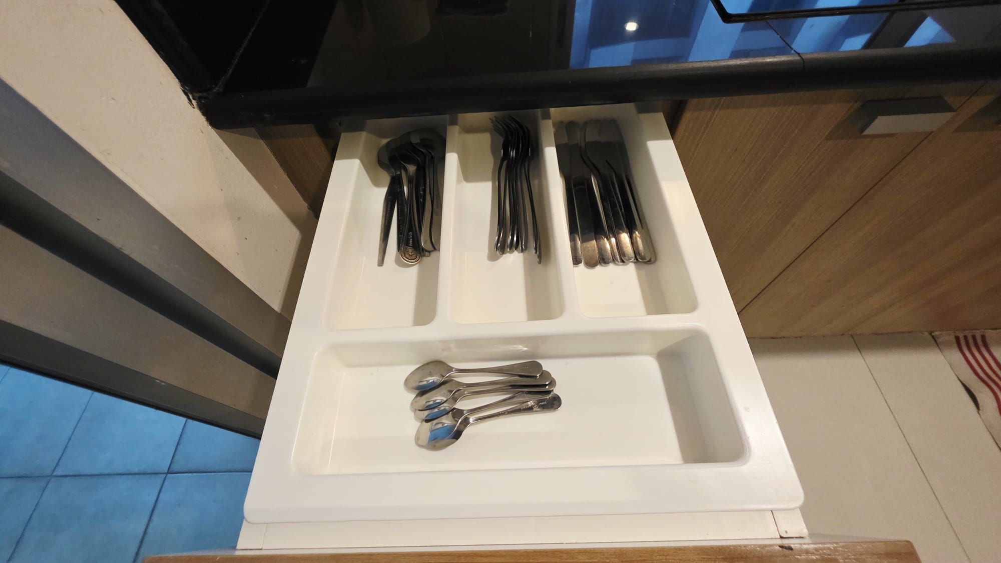 A drawer with utensils including forks, knives, and spoons.