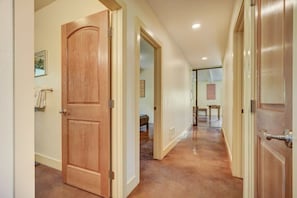 A hallway with wooden doors and a tiled floor.