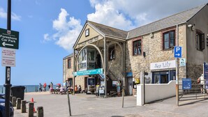 A building with a sign for 'Chatham Heritage Coast Centre' and 'Sea Lily' restaurant. - Cedar (Bridport)