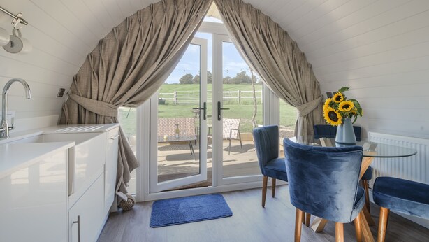 A kitchen with a sliding glass door leading to an outdoor patio area. - Cedar (Bridport)