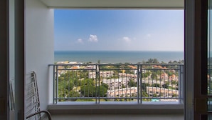 A balcony with a view of a coastal town and the sea.