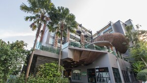 Un bâtiment moderne à plusieurs étages, doté d’une architecture originale, avec une grande structure sphérique sur le niveau supérieur et un balcon en verre.