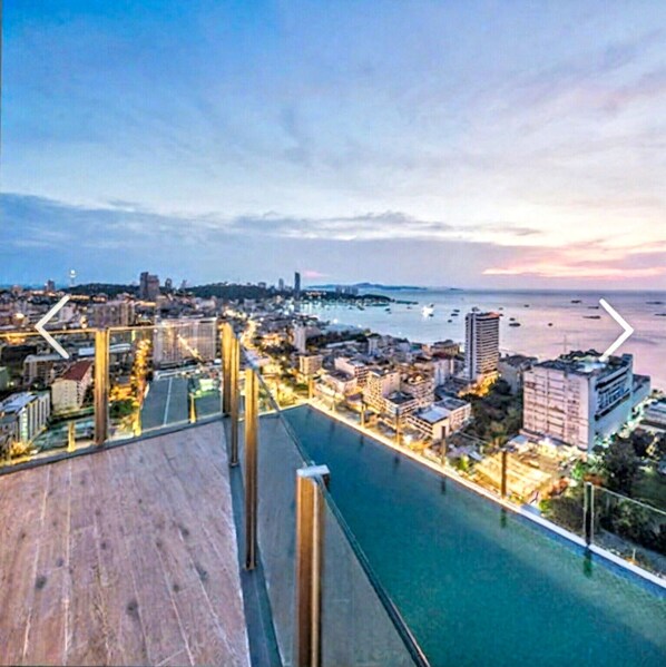A waterfront property with a long balcony overlooking a marina and cityscape.