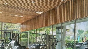 A modern gym with various exercise equipment, large windows, and a wooden ceiling design. - S39- 1 BR Downtown Bangkok Apt with Balcony and Pool (Krung Thep Maha Nakhon)