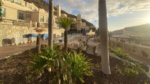 Un resort con area piscina, palme e montagne sullo sfondo.