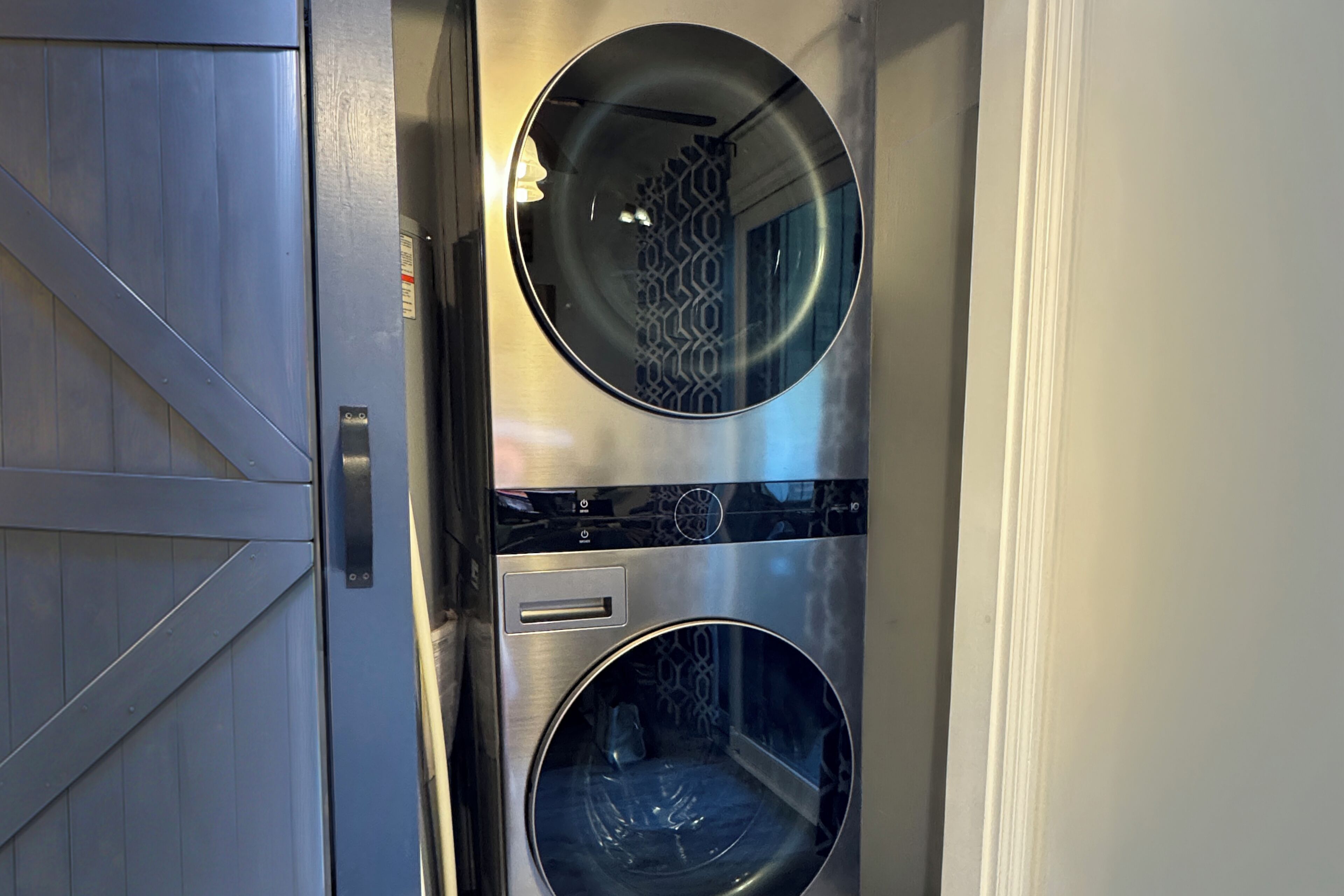 A compact, modern elevator with metallic walls and two circular windows.