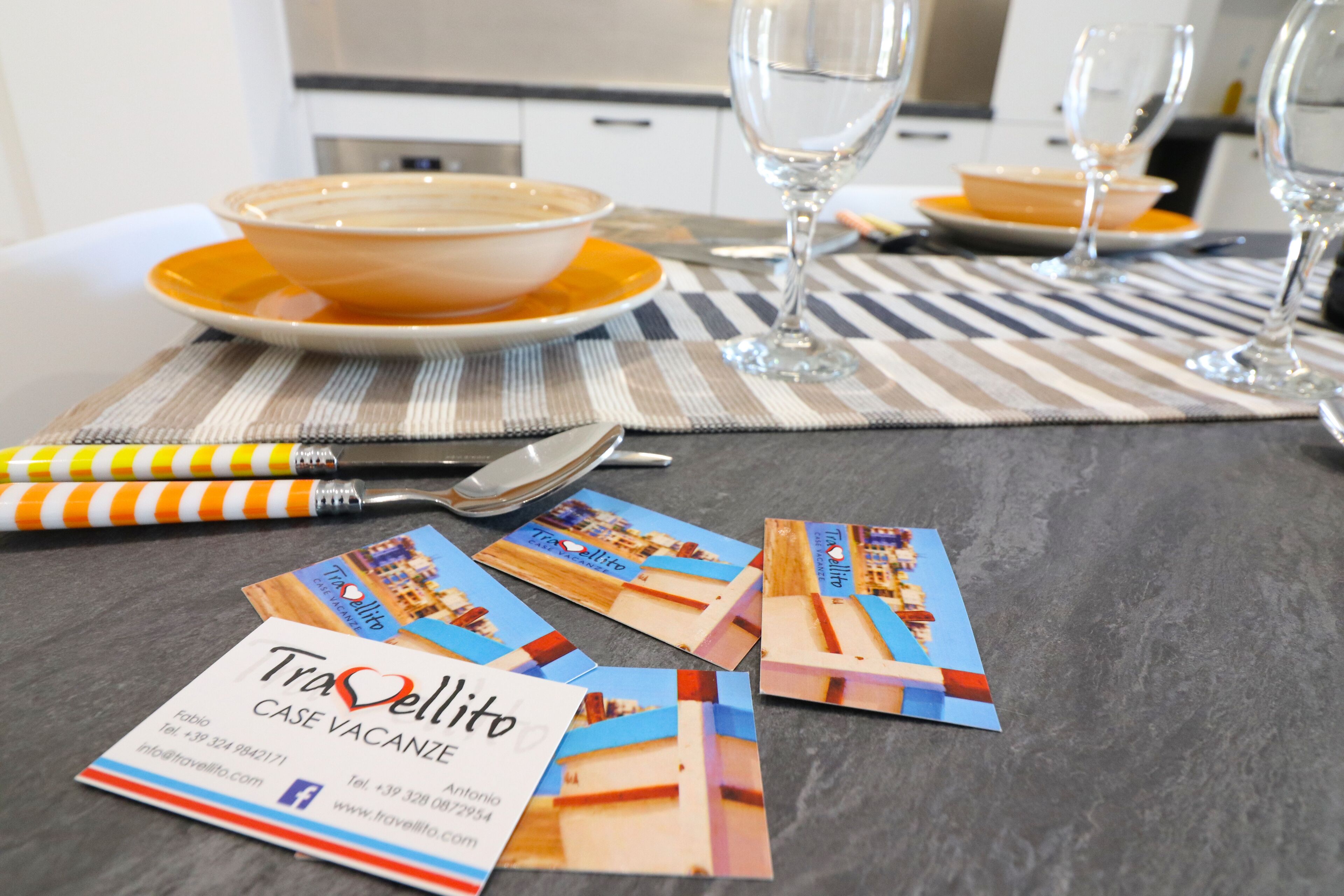 A dining table with a bowl of soup, wine glasses, and business cards.