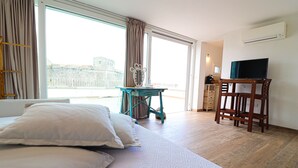 A hotel room with a bed, a desk, a chair, and a television. - Casa Sveva – Romantic studio with panoramic terrace in the heart of Otranto (Otranto)