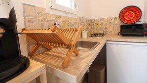 A kitchen with a wooden drying rack, a sink, a stove, and a toaster. - Casa Sveva – Romantic studio with panoramic terrace in the heart of Otranto (Otranto)