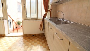 A kitchen with a sink, cabinets, and a window with curtains. - Isabel's house in Otranto 10 seats (Otranto)