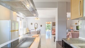 A modern kitchen with a central island, stainless steel appliances, and a dining area with a table and chairs.