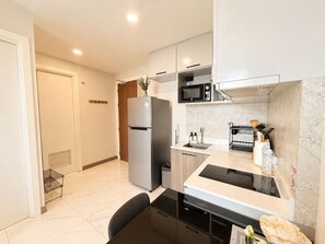 Una cocina moderna con microondas integrado, refrigerador y pileta.